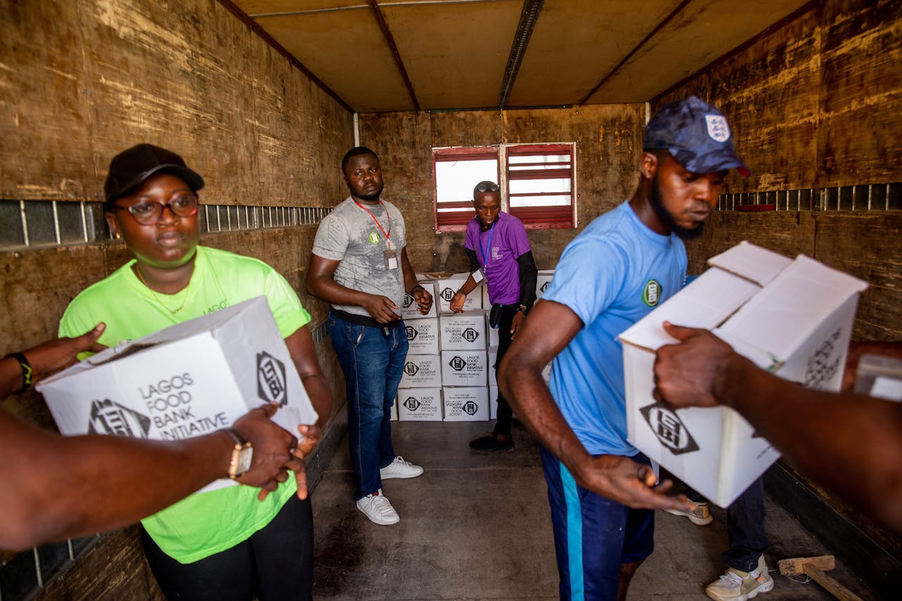 services-04 Dedicated volunteers organize food boxes in a truck for community distribution.